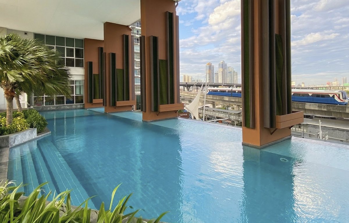 Pool deck with a BTS train passing, The Coast Bangkok